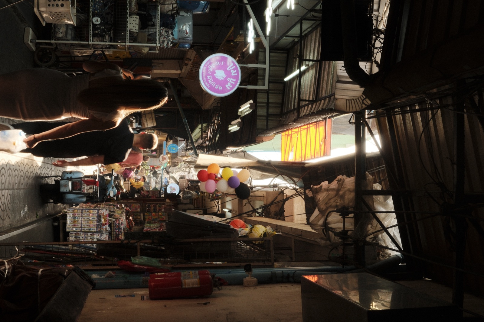 A couple walking through a Bangkok market alley in warm light