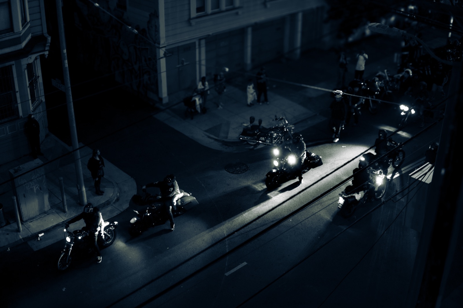 Motorcyclists on a street at night, black and white