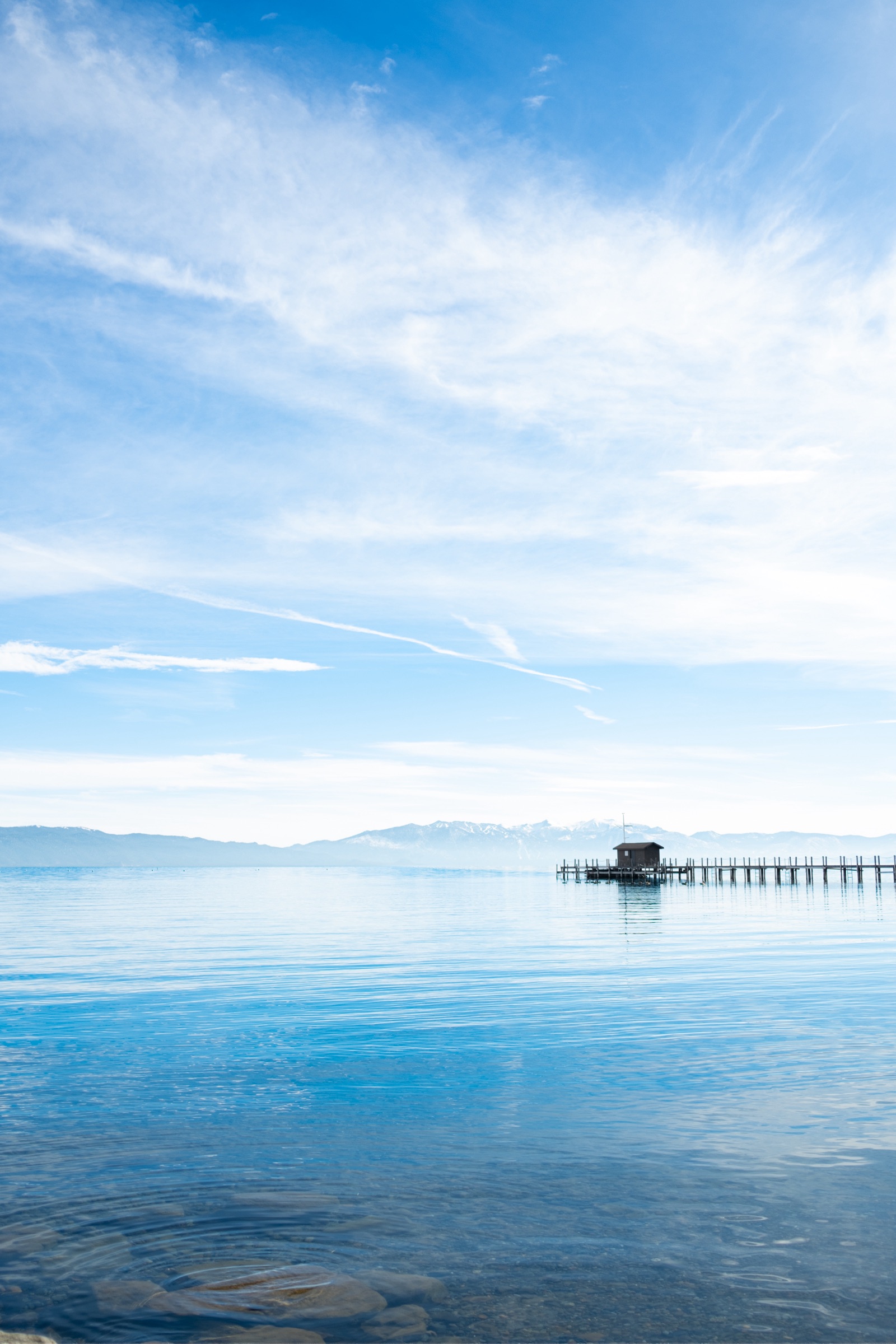 Lake Tahoe with a lone pier under a wide sky