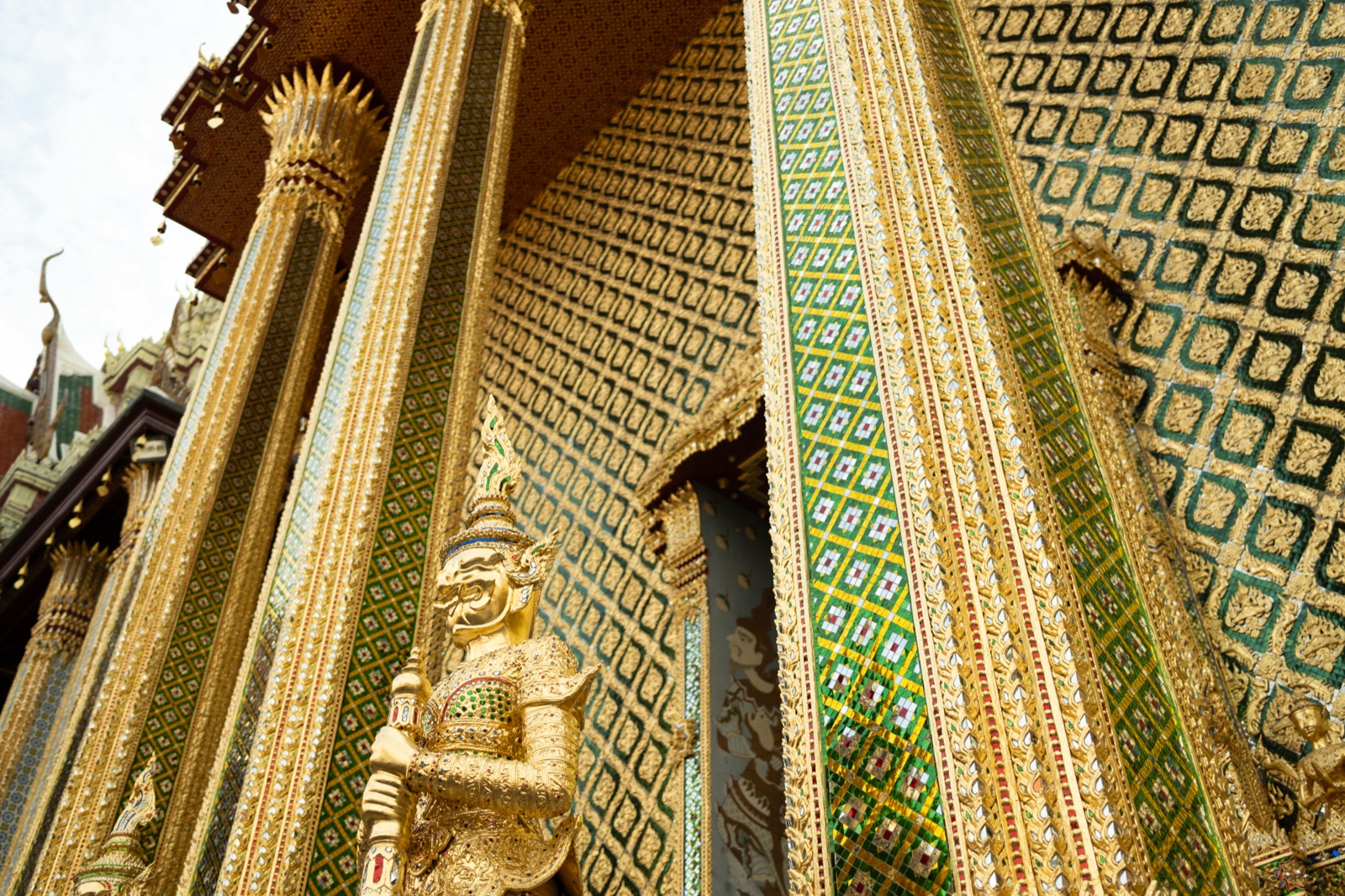 Gilded temple detail with a guardian statue, Bangkok